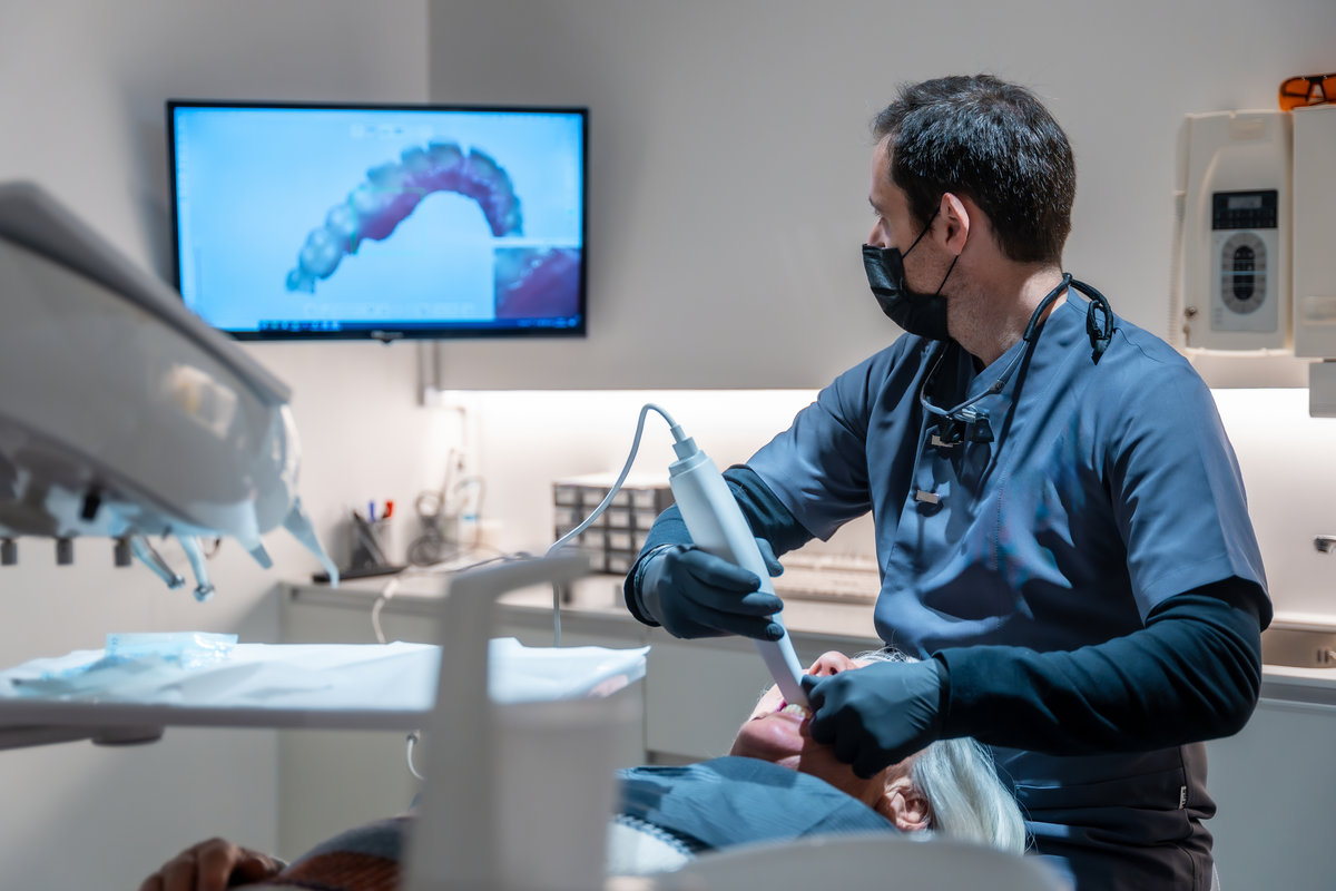 Dentist using an intraoral scanner for 3d scanning of teeth, creating precise digital models for diagnosis and treatment planning